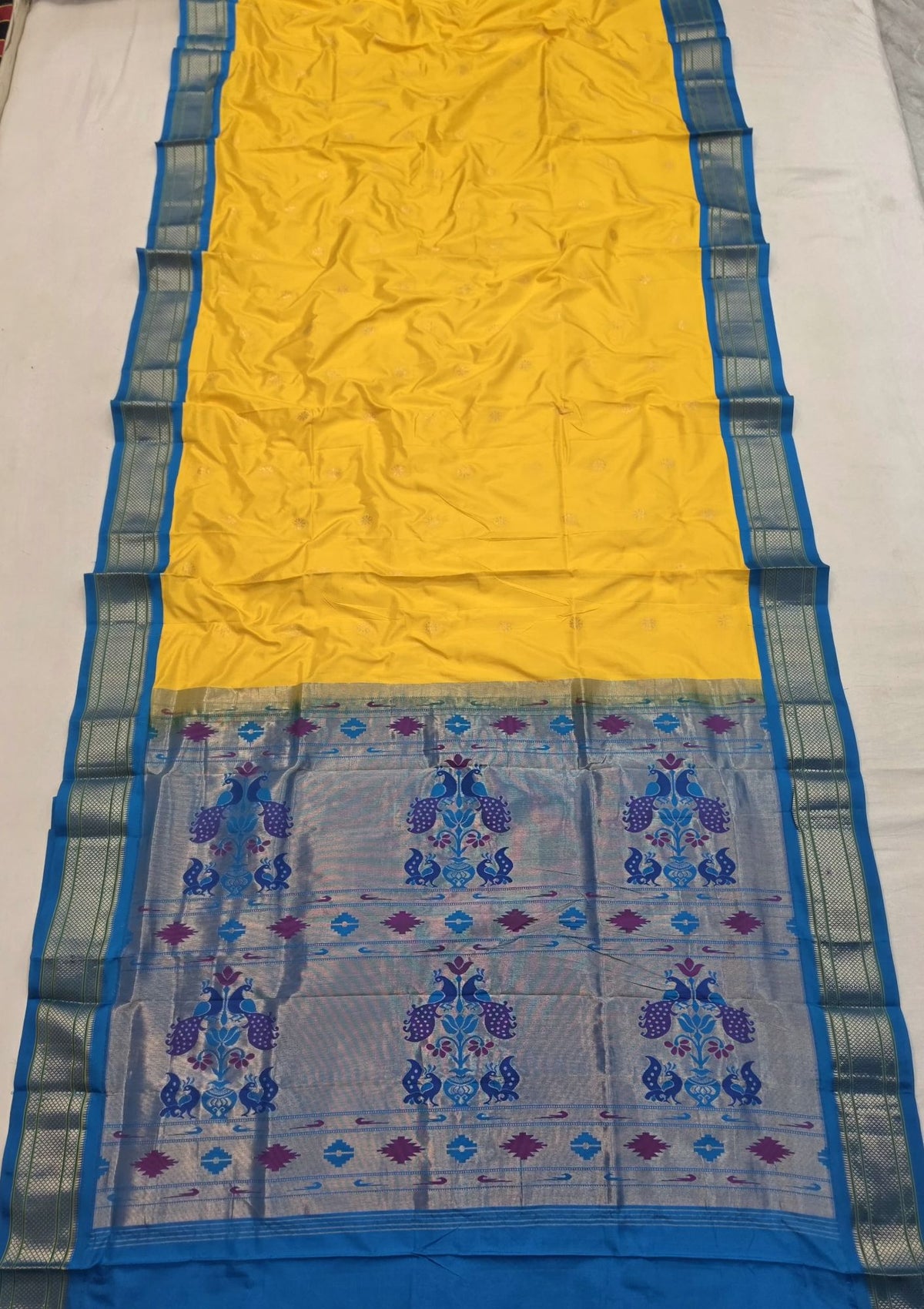 Yellow 9 yard silk Paithani Nauvari saree with blue border, shoulder butta and peacock pallu