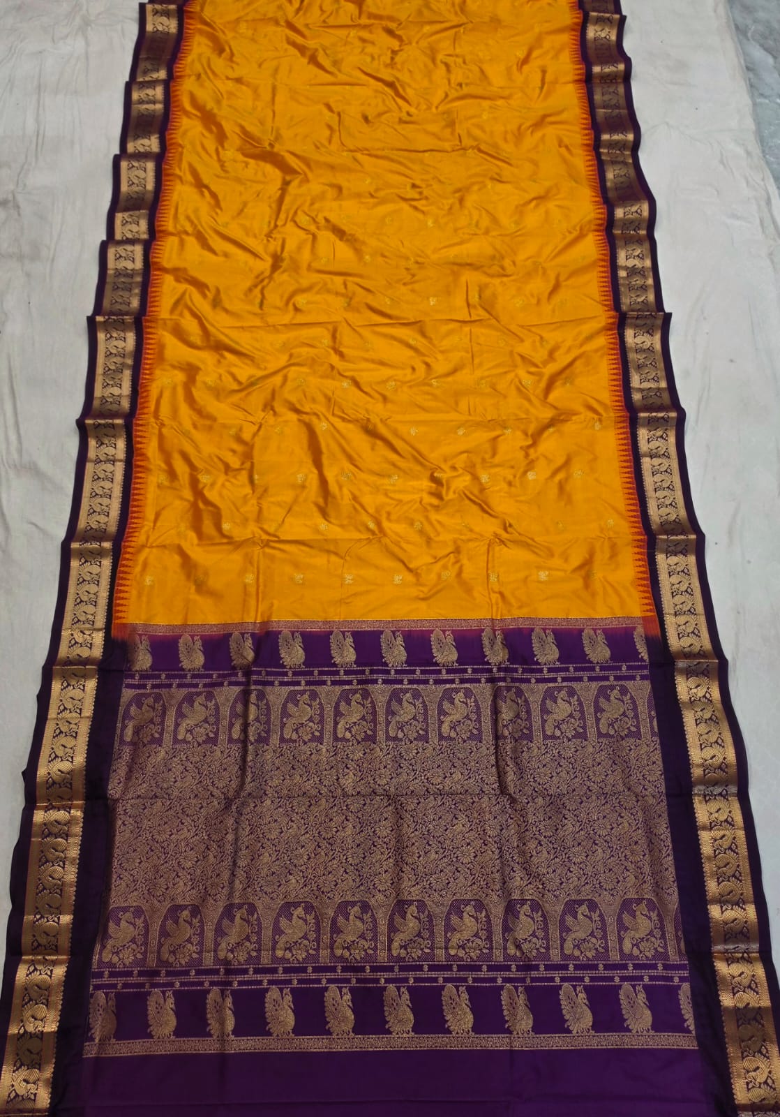 Mustard silk Gadwal saree with purple border, peacock pallu and all-over butta