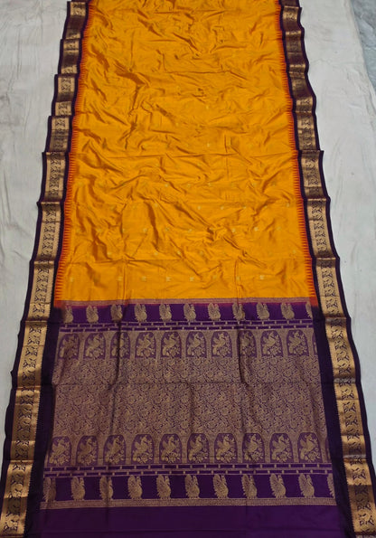 Mustard silk Gadwal saree with purple border, peacock pallu and all-over butta