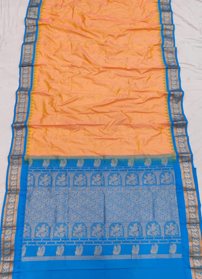Peach silk Gadwal saree with sky blue border, peacock pallu and all-over butta
