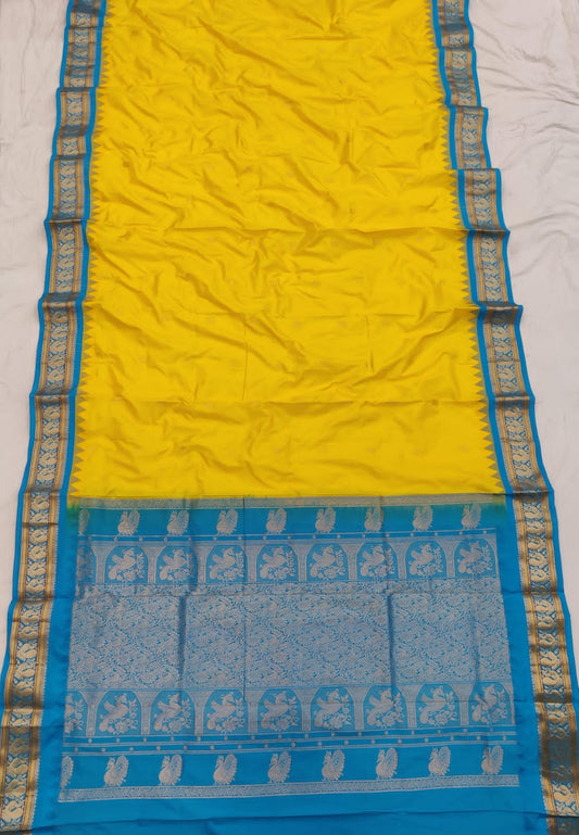 Yellow silk Gadwal saree with sky blue border, peacock pallu and all-over butta